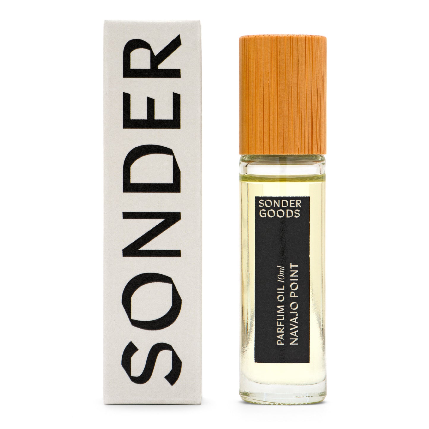 A small, clear glass bottle with a wooden cap, labeled 'Sonder Goods Parfum Oil Navajo Point', next to its white box packaging with the word 'SONDER' in black text.