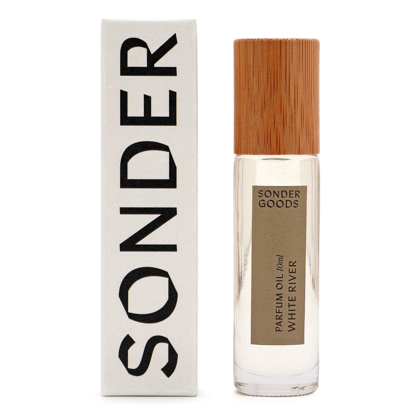 A small, clear glass bottle with a wooden cap, labeled 'Sonder Goods Parfum Oil White River', next to its white box packaging with the word 'SONDER' in black text.