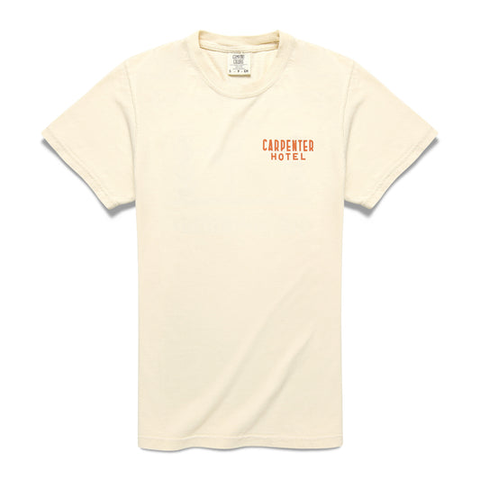 A beige Carpenter Hotel Tee with short sleeves and the logo 'CARPENTER HOTEL' printed on left side of the chest.