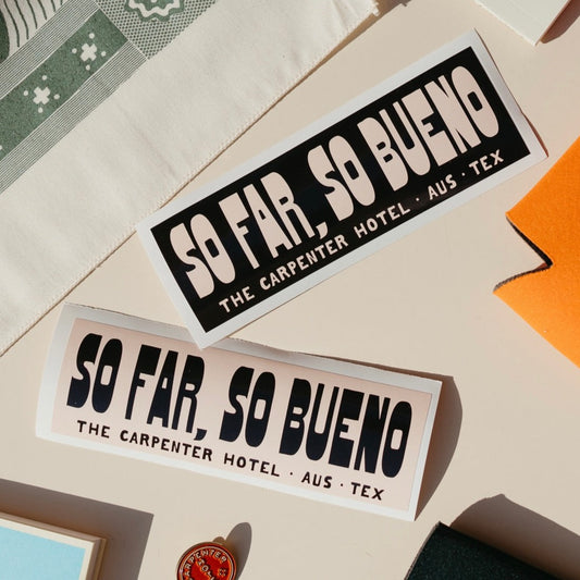 Stickers with the text 'SO FAR, SO BUENO THE CARPENTER HOTEL AUST TEX' printed on it in contrasting beige and black graphic, displayed on a neutral background.